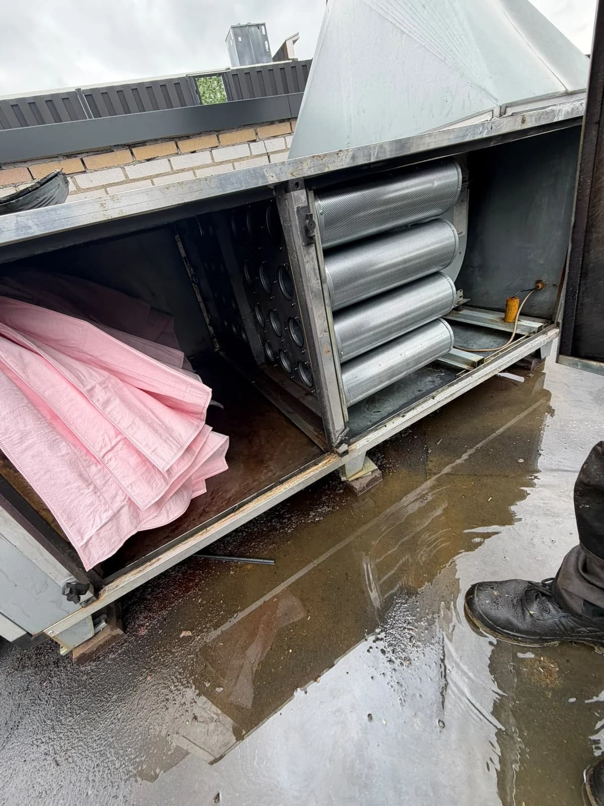 Rooftop maintenance on an odor control unit with inspection of pocket filters and carbon cylinders.