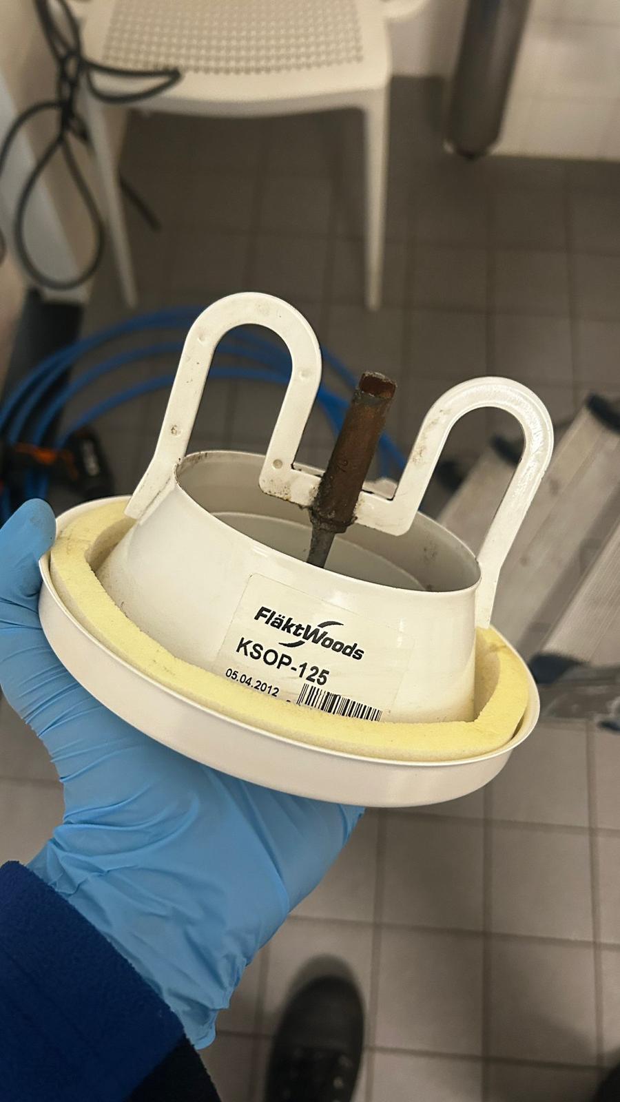 Uitgenomen ventilatieventiel getoond in een gehandschoende hand