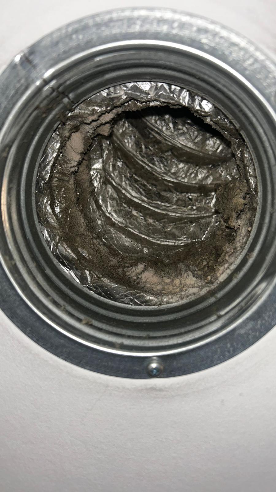 Ronde ventilatieopening met sterke vervuiling in de leiding