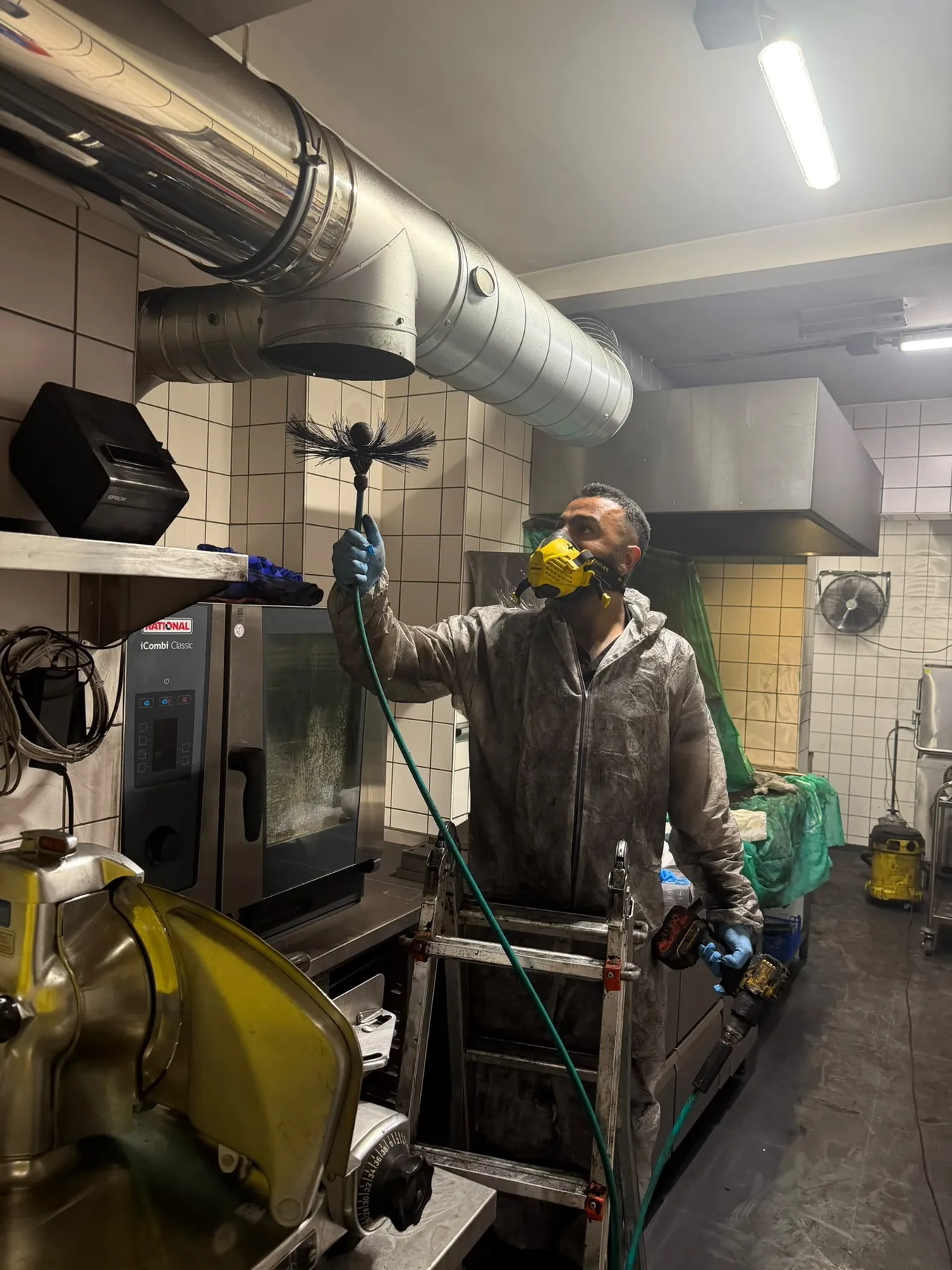 Technical cleaning of an air duct inside a professional building.